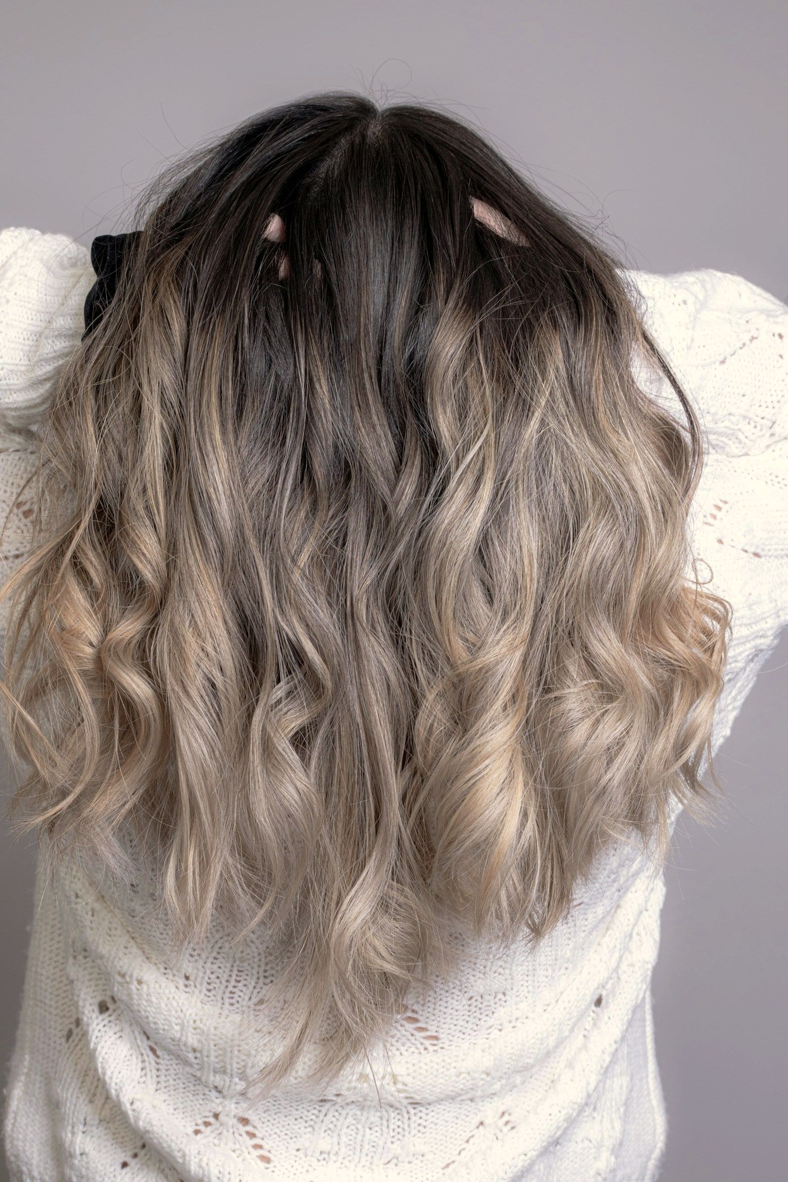 Wellen in kühlem Blond mit dunklerem Ansatz, von hinten